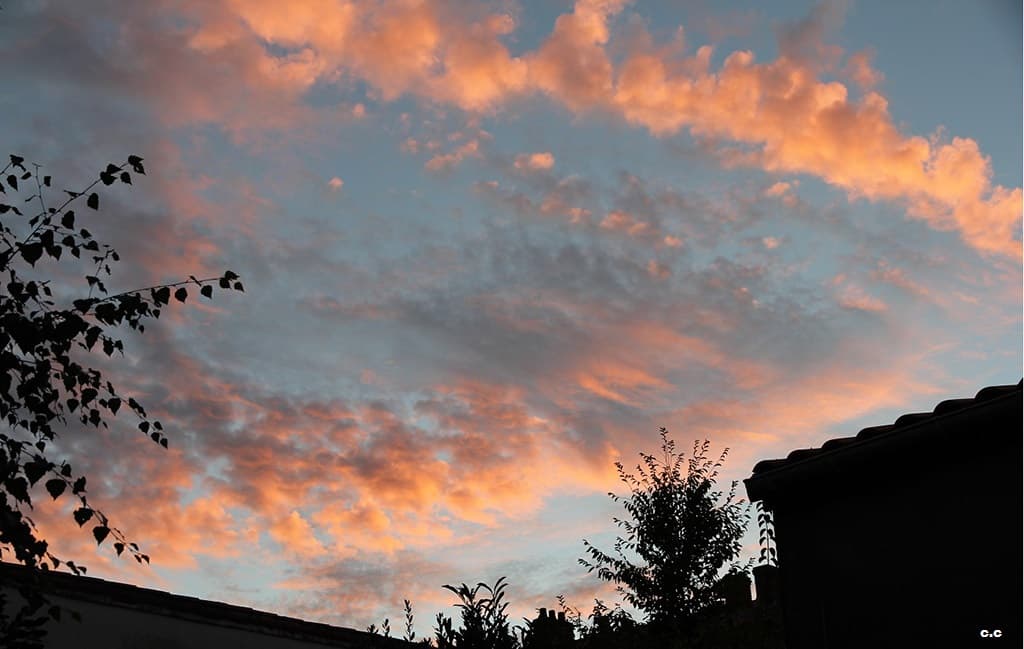 les nuages par dessus les toits s'embrasent